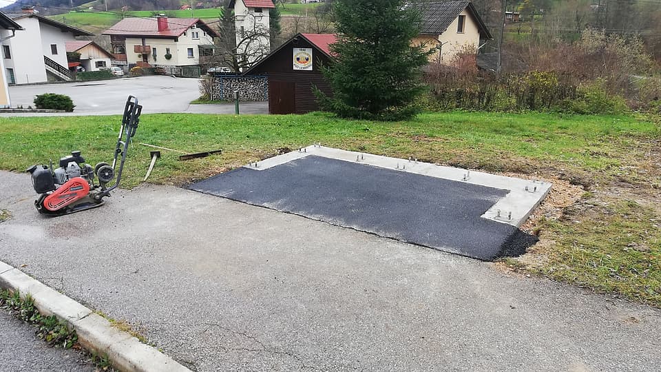 Sveže asfaltirana ploščad ob avtobusnem postajališču